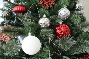 Bent wire ornaments, in the shape of a star and Christmas tree, hanging on a Christmas tree.