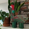 Christmas Dino Decoration - finished dino decoration on the mantel next to two potted plants