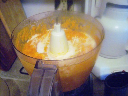 Adding coconut milk to the food processor.