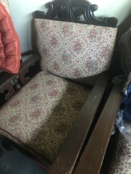 A carved wooden chair with fabric cushions.