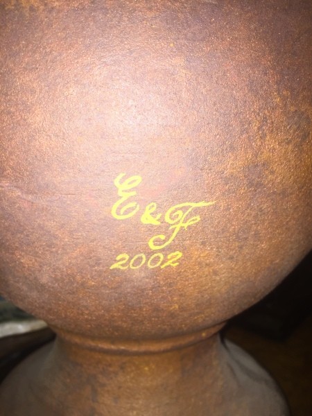 A signature on the back of a decorative jar.