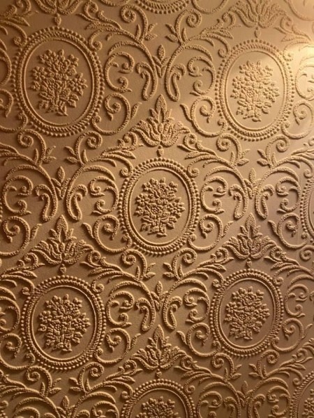 Ornate wallpaper with a raised design.