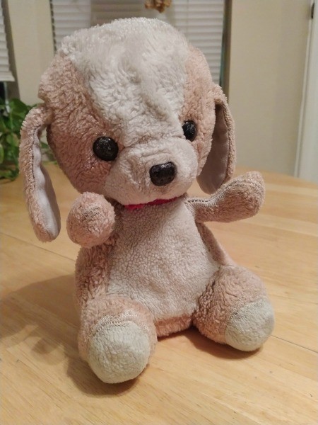 A small brown and white stuffed dog.