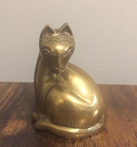 A small brass figurine of a cat.