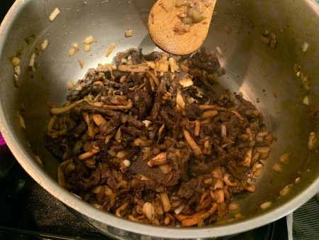 Adding the cooked ingredients to a mixing bowl.