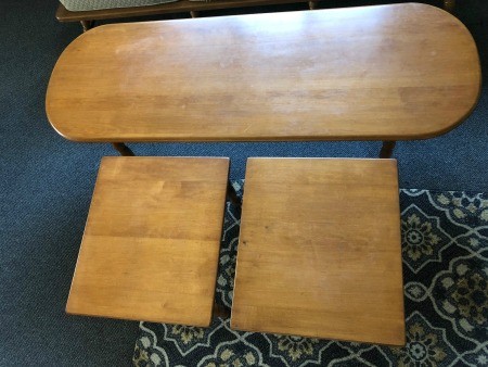 A long oval coffee table with two smaller side tables.