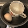 A pan with a mug inside to limit the volume when boiling an egg.