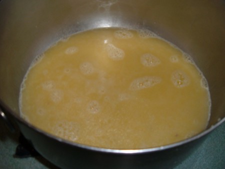 Adding the broth mixture to a bowl.