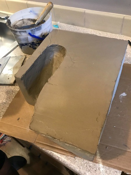 Covering the styrofoam with grout.