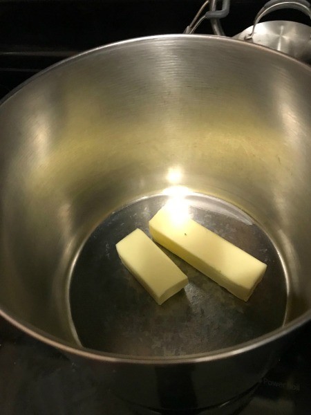 Melting butter in the bottom of a soup pot.
