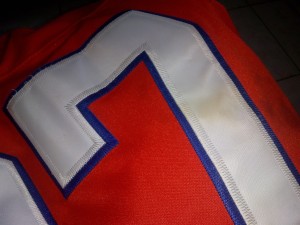 A yellow stain on the white number on a jersey.