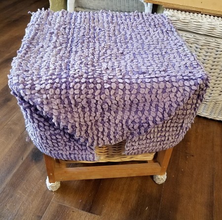 Converting a Drawer Unit Into a Footstool - folded and tied rug in place over the drawer unit and booties on legs