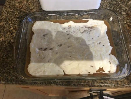 Spreading melted marshmallows as a layer.