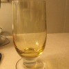 A footed glass with a yellow tint.