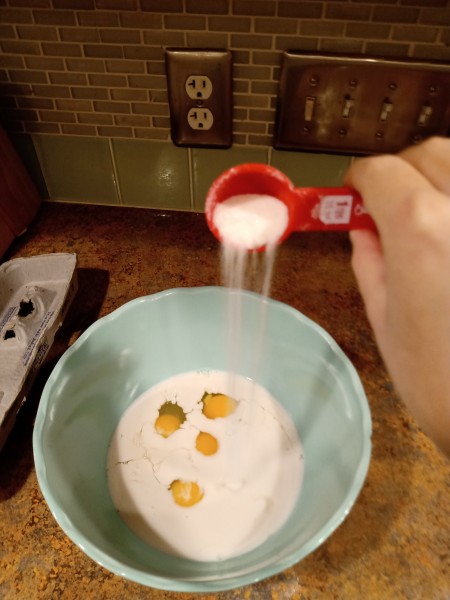 Adding sugar to the mixture.