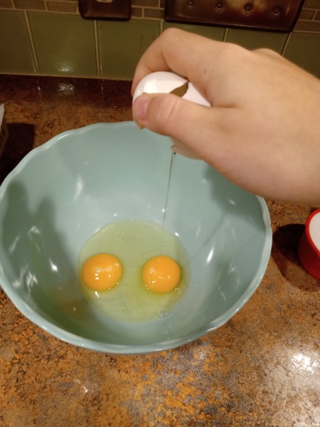 Cracking eggs in a bowl.