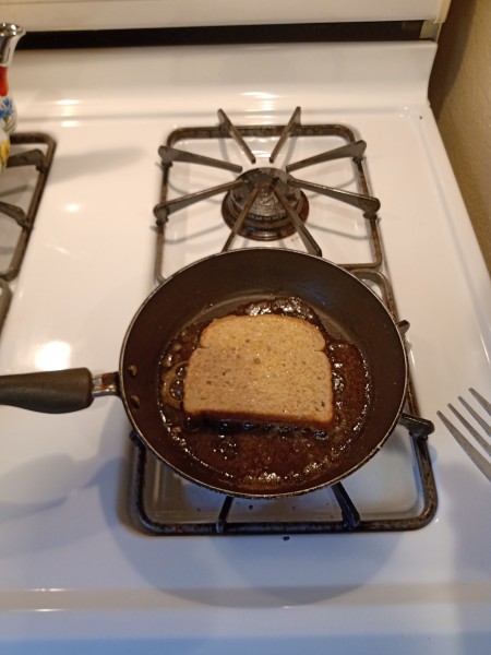 Cooking the French toast in a frying pan.