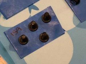 Keeping Track of Screws When Assembling a Treadmill - closeup of button head machine screws on blue painter's tape