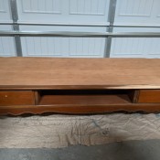 A low wooden table with drawers.