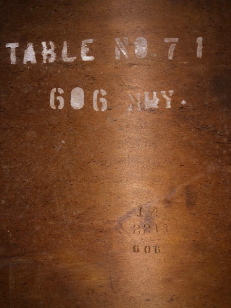 The marking on the underside of a dining table.