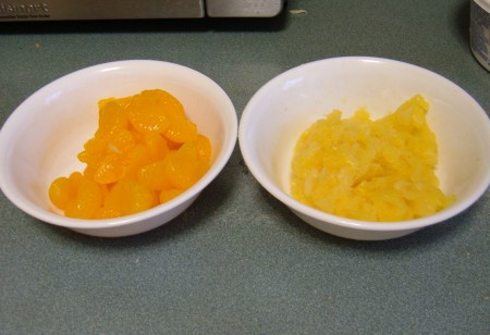 Bowls of canned mandarin oranges and pineapple.