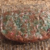 A loaf of cranberry apple banana bread cooling on a rack.