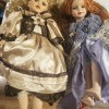 Two porcelain dolls in fancy dresses.