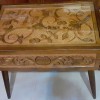 An ornately carved wooden end table.