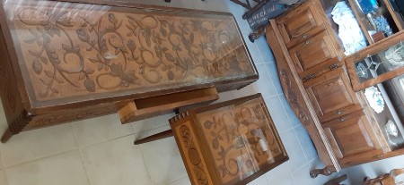 Ornately carved tables with glass surfaces.