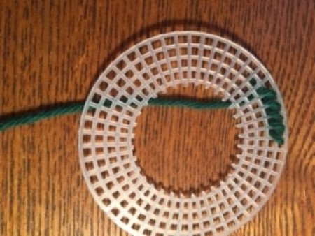 Adding yarn to the outside of the circle canvas.