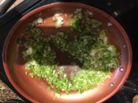 Sauteing vegetables in a frying pan.