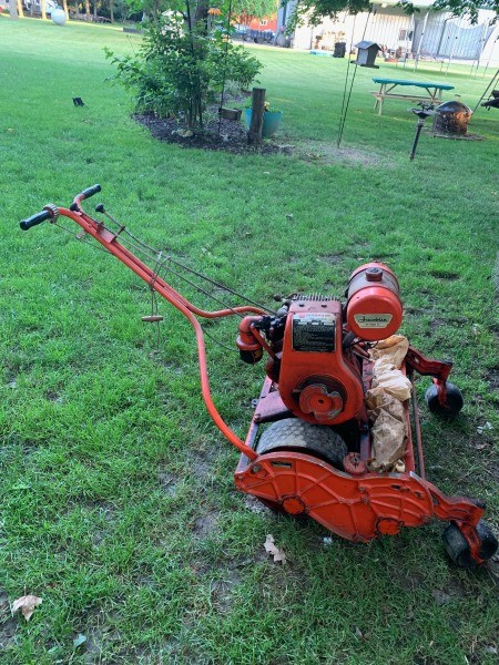 A vintage mower on a lawn.