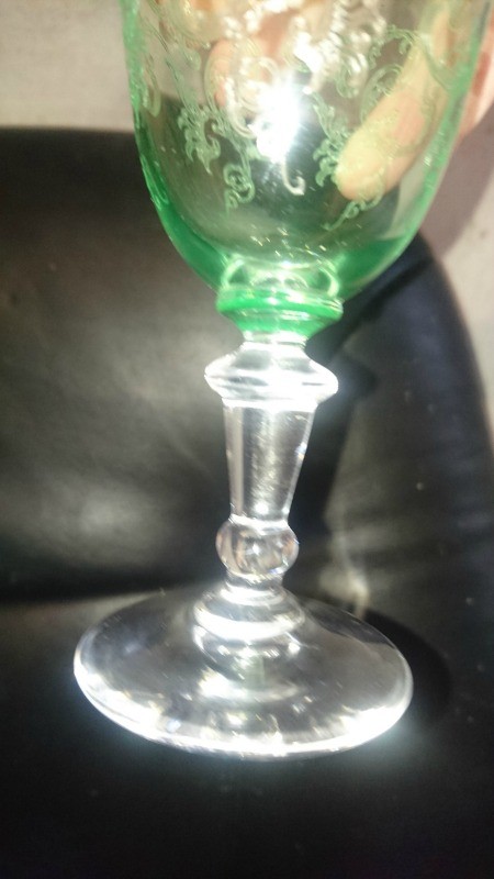 A green glass goblet with a clear stem.