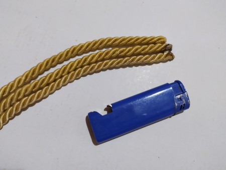 Using a lighter to melt the ends of the cord.
