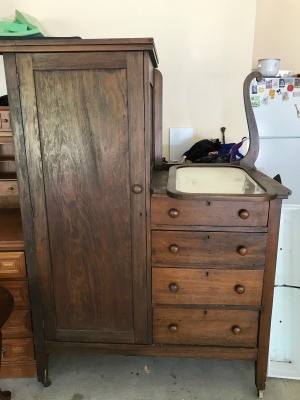 An antique chiffarobe with drawers on one side.