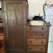 An antique chiffarobe with drawers on one side.