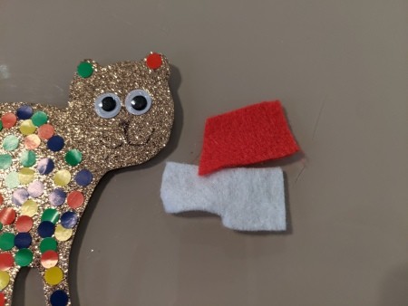Cutout pieces of felt for a Santa hat.