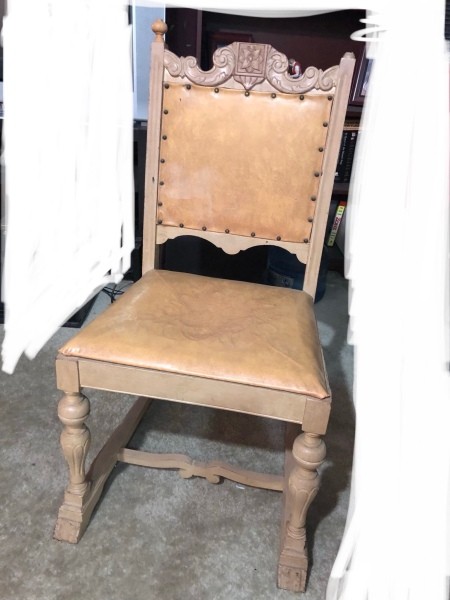 A set of wooden chairs with leather seats and backs.