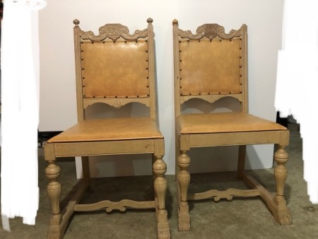 A set of wooden chairs with leather seats and backs.