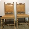 A set of wooden chairs with leather seats and backs.