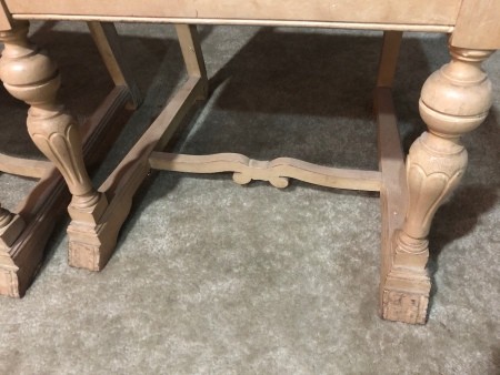 A close up of the feet of an antique chair.