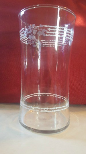 A vintage glass with stripes and flowers at the top.
