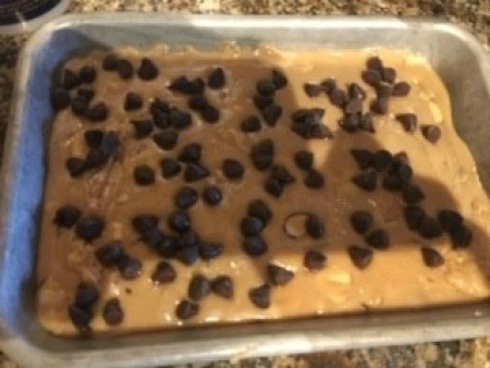 Spreading chocolate chips on top of the toffee.