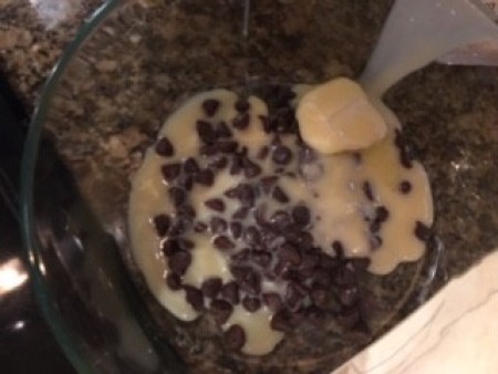 Mixing chocolate, butter and condensed milk together in a bowl.