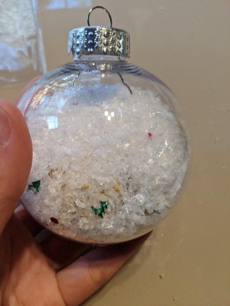 The clear ornament filled with snow and glitter.
