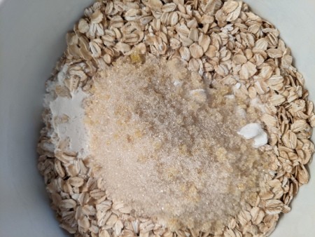 Adding the sugar mixture to oats.