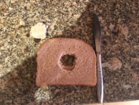 Cutting a hole in bread for the egg.