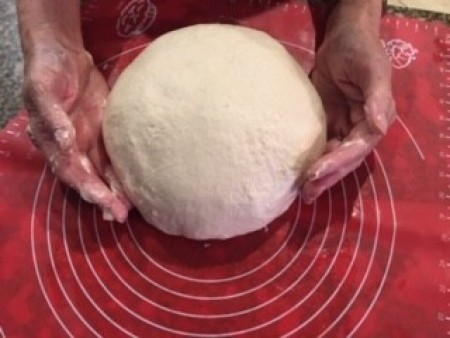 A ball of dough on a rolling mat.