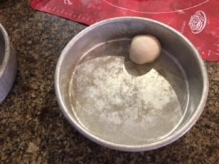 Adding small dough balls to the pan.