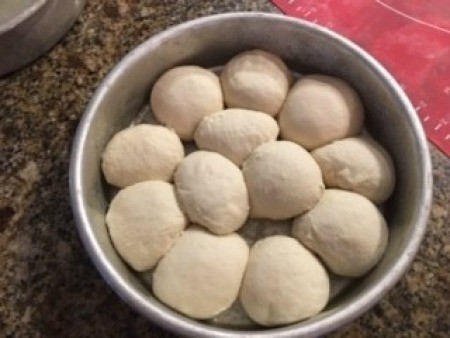 A round pan filled with small balls of dough.